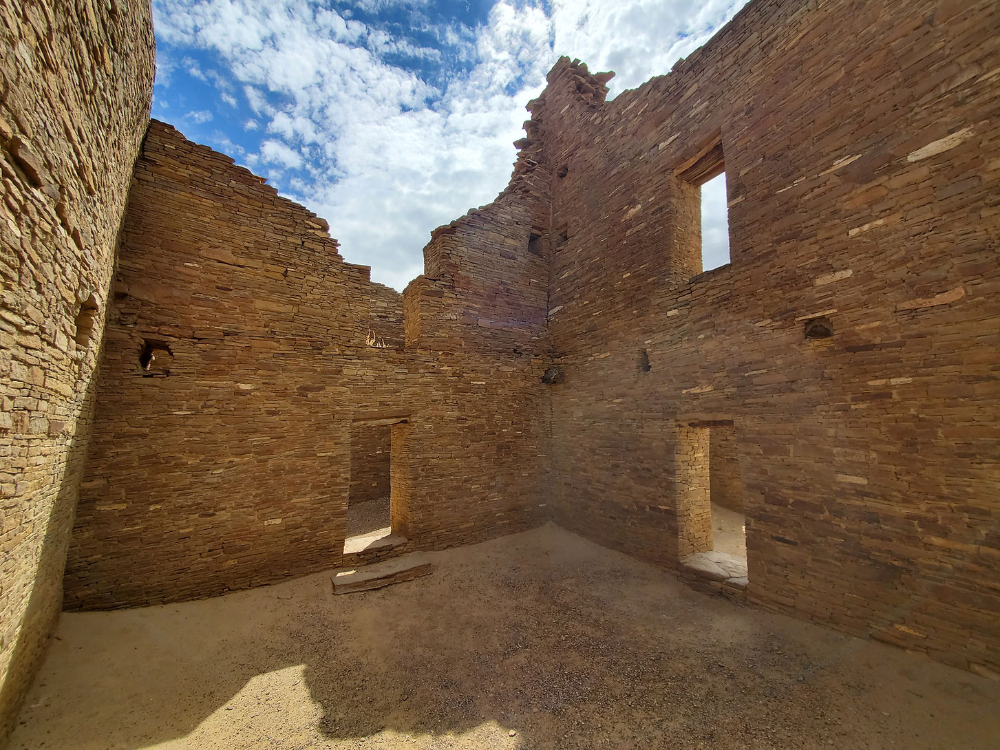 Ancient stone ruins with doorways under a blue sky