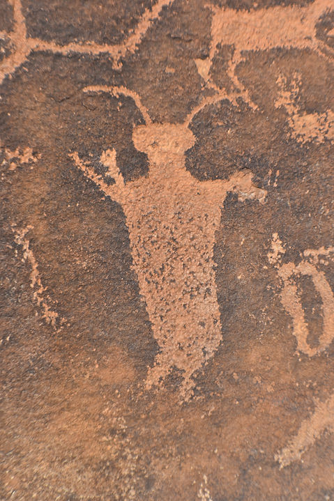 Ancient petroglyph of a humanoid figure with antennae