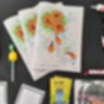 Three copies of the It Comes In Waves zine in a fan shape laid on the table