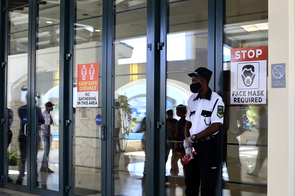 A security guard stands at the entrance of to uphold COVID-19 Protocols.