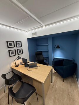 Despacho con pared azul, escritorio de madera y sillón azul