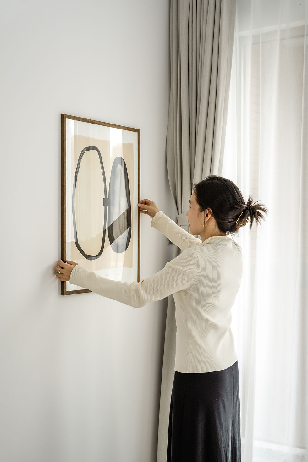 Lady hanging artwork on wall