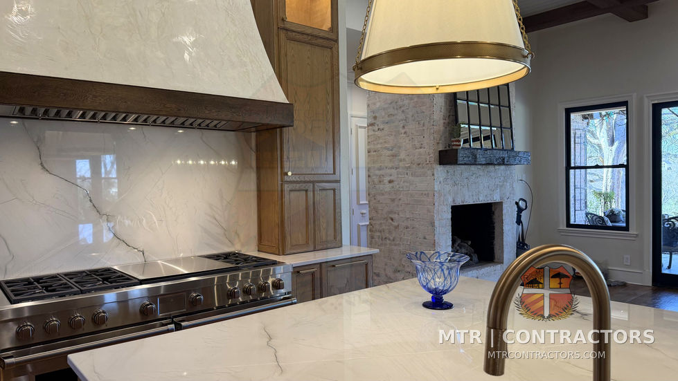 Professional range and hood with quartzite slab and pendant lighting above — kitchen remodel in Little Elm, TX by MTR Contractors of Frisco