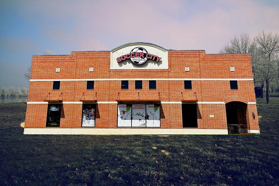 Exterior view of Soccer City Frisco, a brick two-story building with a large sign featuring a soccer ball logo above the entrance, located in the Rail District.