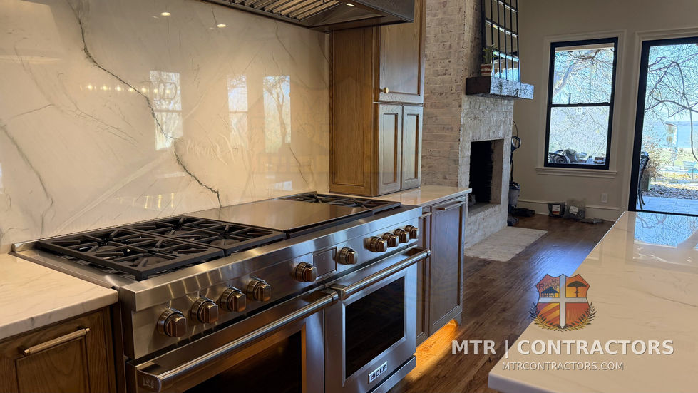 Six-burner professional range set into white oak cabinetry with quartzite — kitchen remodel in Little Elm, TX by MTR Contractors of Frisco