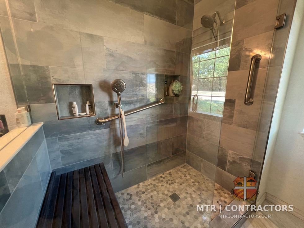 Accessible shower interior with bench and pebble floor tile — shower remodel in Plano, TX by MTR Contractors of Frisco