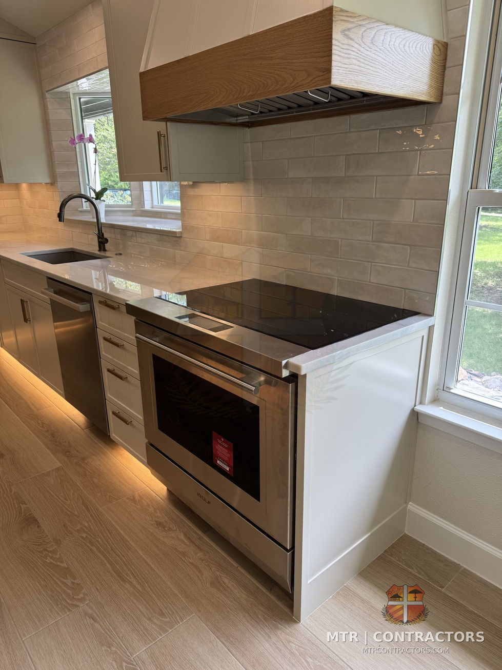Range and custom hood with under-cabinet lighting — whole-home remodel by MTR Contractors, Frisco TX