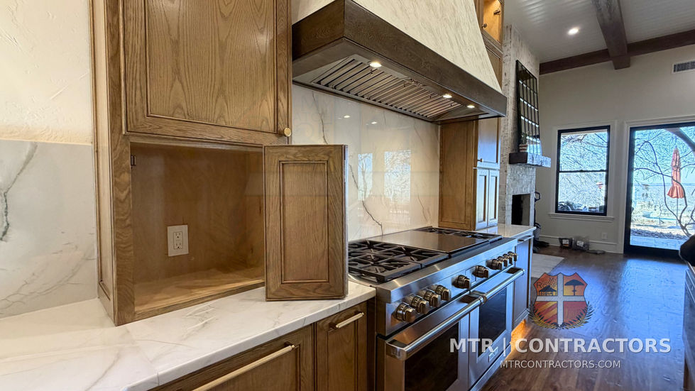 Range wall with unbroken quartzite veining and rift-cut white oak cabinetry — kitchen remodel in Little Elm, TX by MTR Contractors of Frisco