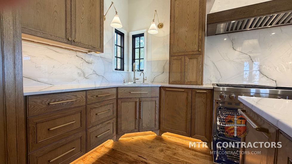 White oak cabinet run with quartzite counters along the window wall — kitchen remodel in Little Elm, TX by MTR Contractors of Frisco