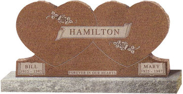 A cemetery monument shaped like a double heart in light brown
