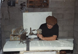 A stonemason at work making designs on a gravestone