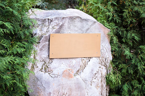 Blank plaque on the stone. Bronze memorial plaque in the park. Empty sign board on the wal