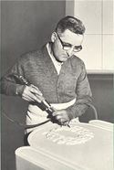 A stonemason carving designs on a piece of stone