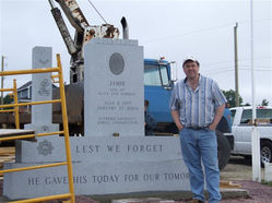 A man standing next to a large memorial piece on display
