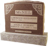 A brown cemetery monument with floral designs engraved on the top corners