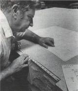 A man using a ruler to measure designs