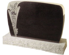 A black cemetery monument with intricate engravings made on it