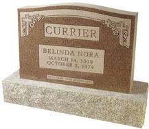 A light brown cemetery monument with engravings made on it