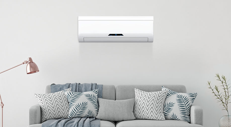Wall-mounted split air conditioner installed above a modern sofa in a bright living room, representing Servico’s professional