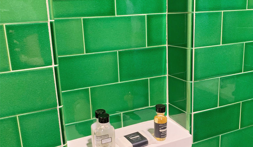 Shower shelf with toiletries, Emerald green bathroom, Emerald Room, elegant room, Pioneer Woman Boarding House Hotel, Pawhuska, Oklahoma