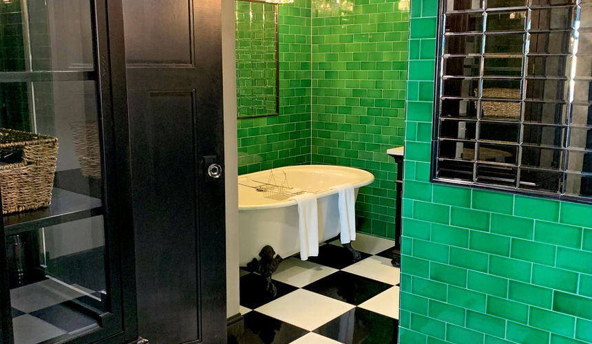 Emerald green bathroom and tub, silver details bathroom, Emerald Room, black and white checkered floor, elegant room, Pioneer Woman Boarding House Hotel, Pawhuska, Oklahoma