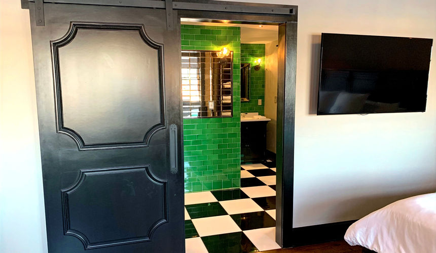 Dark wood barn door, Emerald green bathroom, silver details bathroom, Emerald Room, elegant room, Pioneer Woman Boarding House Hotel, Pawhuska, Oklahoma