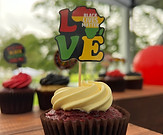 A chocolate cupcake with vanilla frosting and a cupcake topper that says "Love" and the O is represented by the shape of Africa and says "Black Lives Matter"