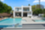 Modern luxury home exterior with glass balcony and custom pool, professionally photographed by Ashley Blackmer Photography in