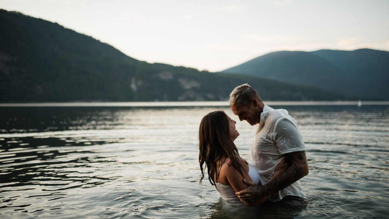 Couple embracing in Shuswap lake during a summer engagement session