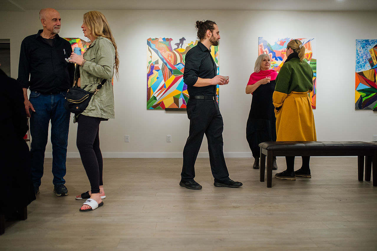 Candid moment of guests interacting during the Barry J. Games exhibition at Atelier - A Way of Being by Salmon Arm Photographer the Dark Room Studio