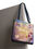 Thumbnail: Close-up of whimsical butterfly and heart design on Mystic Matt floral tote bag