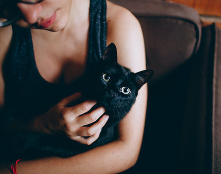 girl holding and cuddling a black cat in her lap