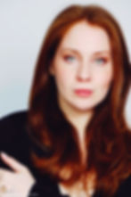 Lillee Jean Trueman official director and actress, in a professional portrait 2025. She is wearing a black blazer with her red hair side-parted, highlighting her fierce blue-green eyes.