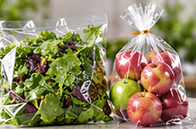 Fresh produce: Salad leaves and apples packed in clear bags.