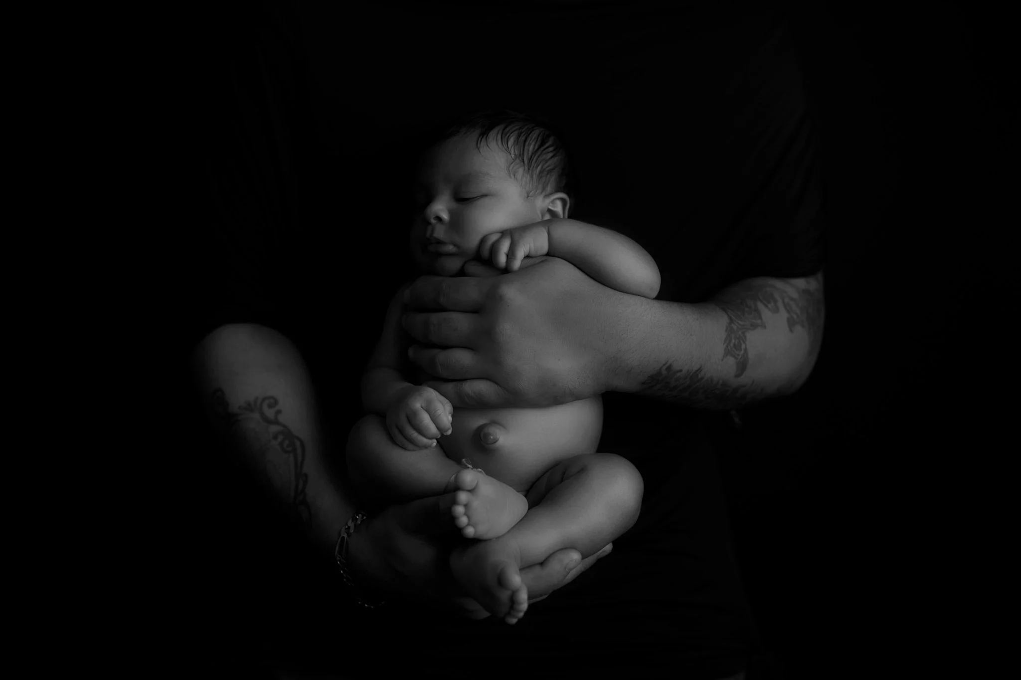 black and white newborn baby portrait in Dad's hands taken by NH Baby photographer Vanessa Keo