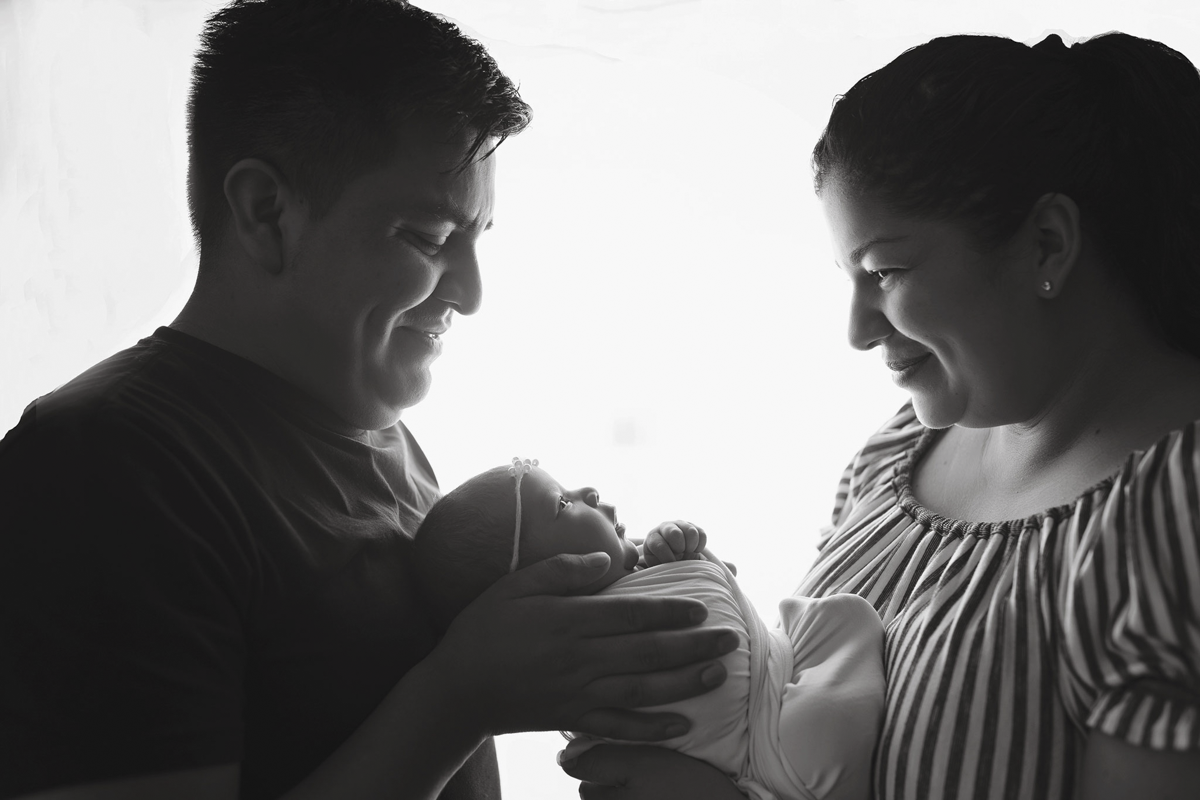 black and white newborn and family photo with parents smiling taken by NH newborn photographer Vanessa Keo