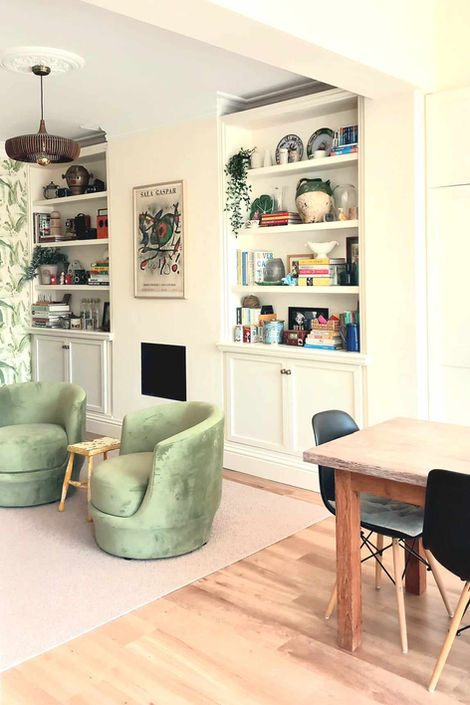 Edwardian extension inner room with alcoves, cabinets, botanical wallpaper, green velvet armchairs, and ribbed oak pendant