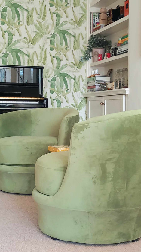 Close-up of light green velvet armchairs with vintage coffee table and botanical wallpaper in Edwardian extension inner room