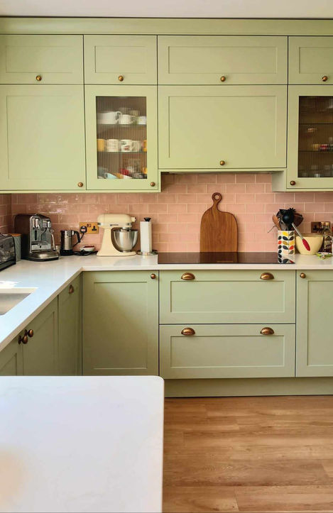 New light green kitchen with pink metro-style tile splashback, warm inviting interior