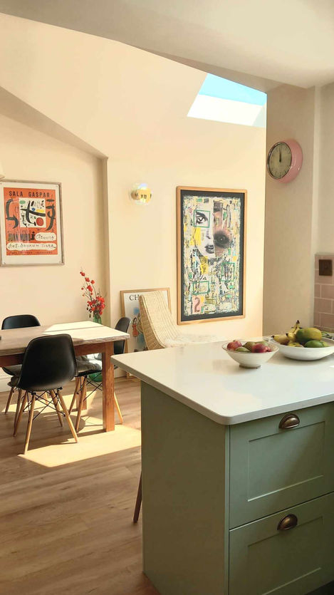 Kitchen island connecting kitchen to enlarged dining area, cathedral roof with ridge rooflight and apex window, oak table with rattan chairs