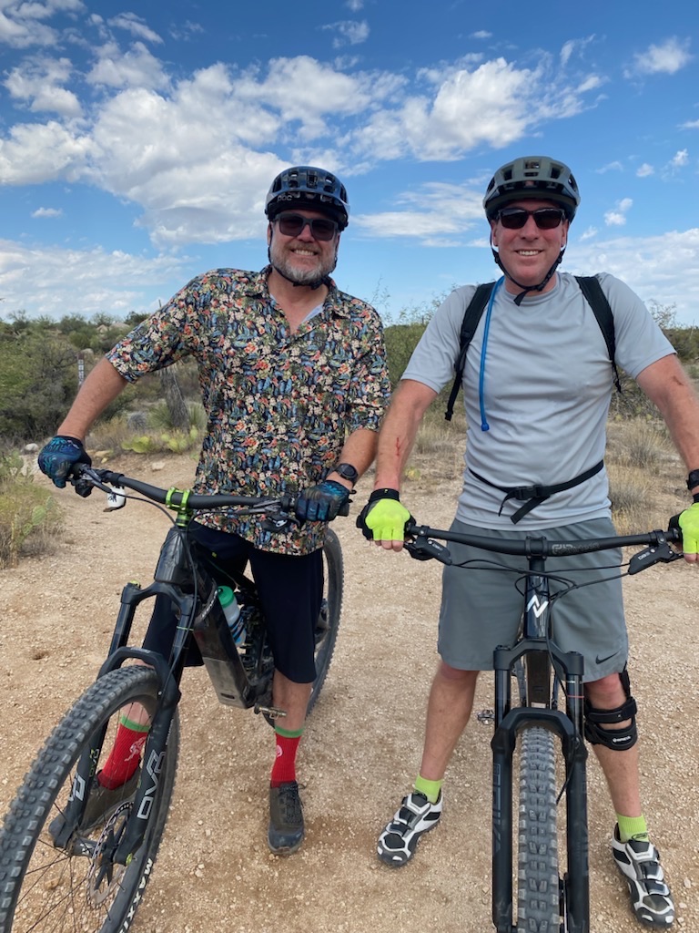 Tyler and another rider with mountain bikes on a desert trail