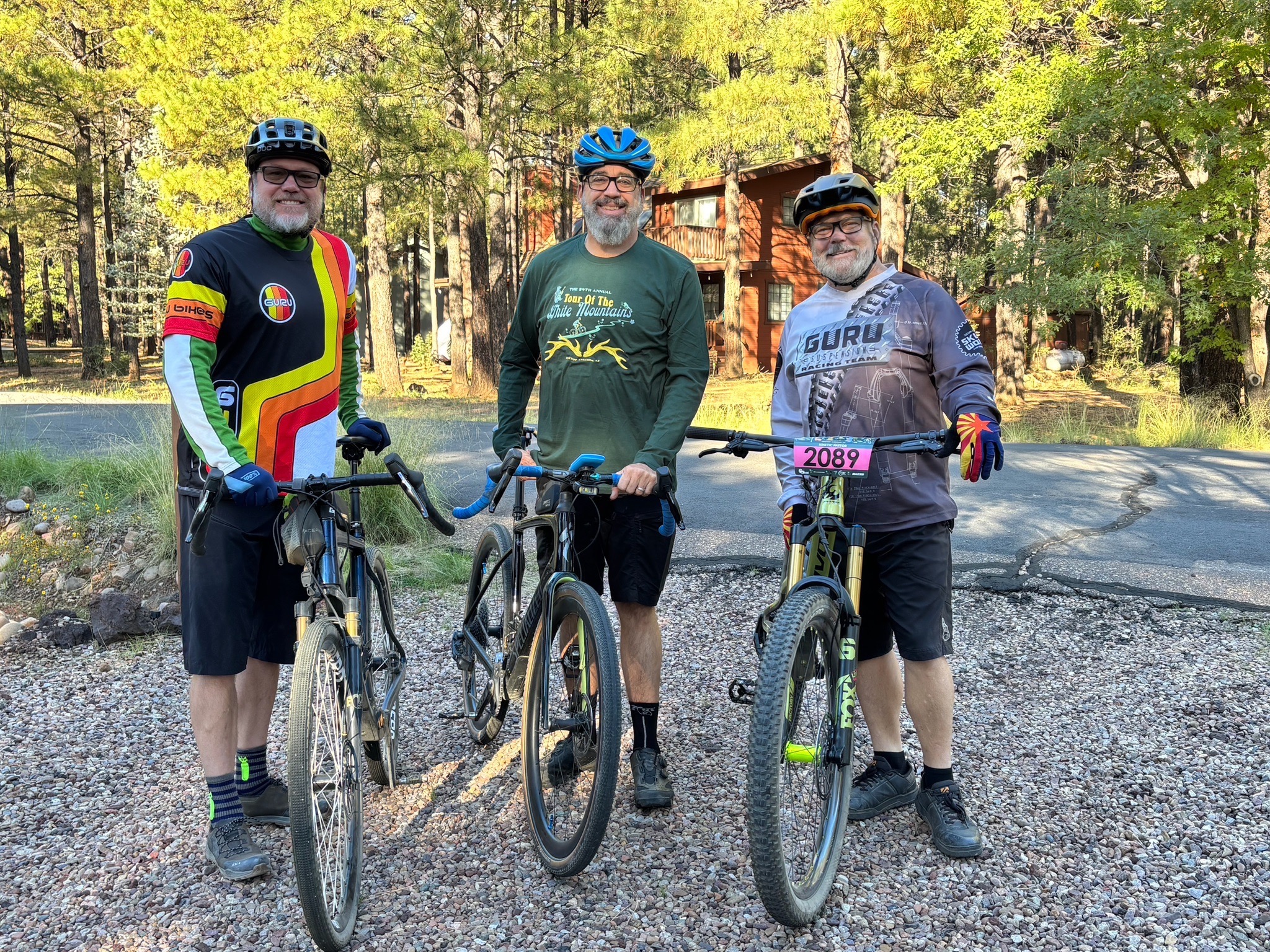 Three cyclists with their bikes outdoors