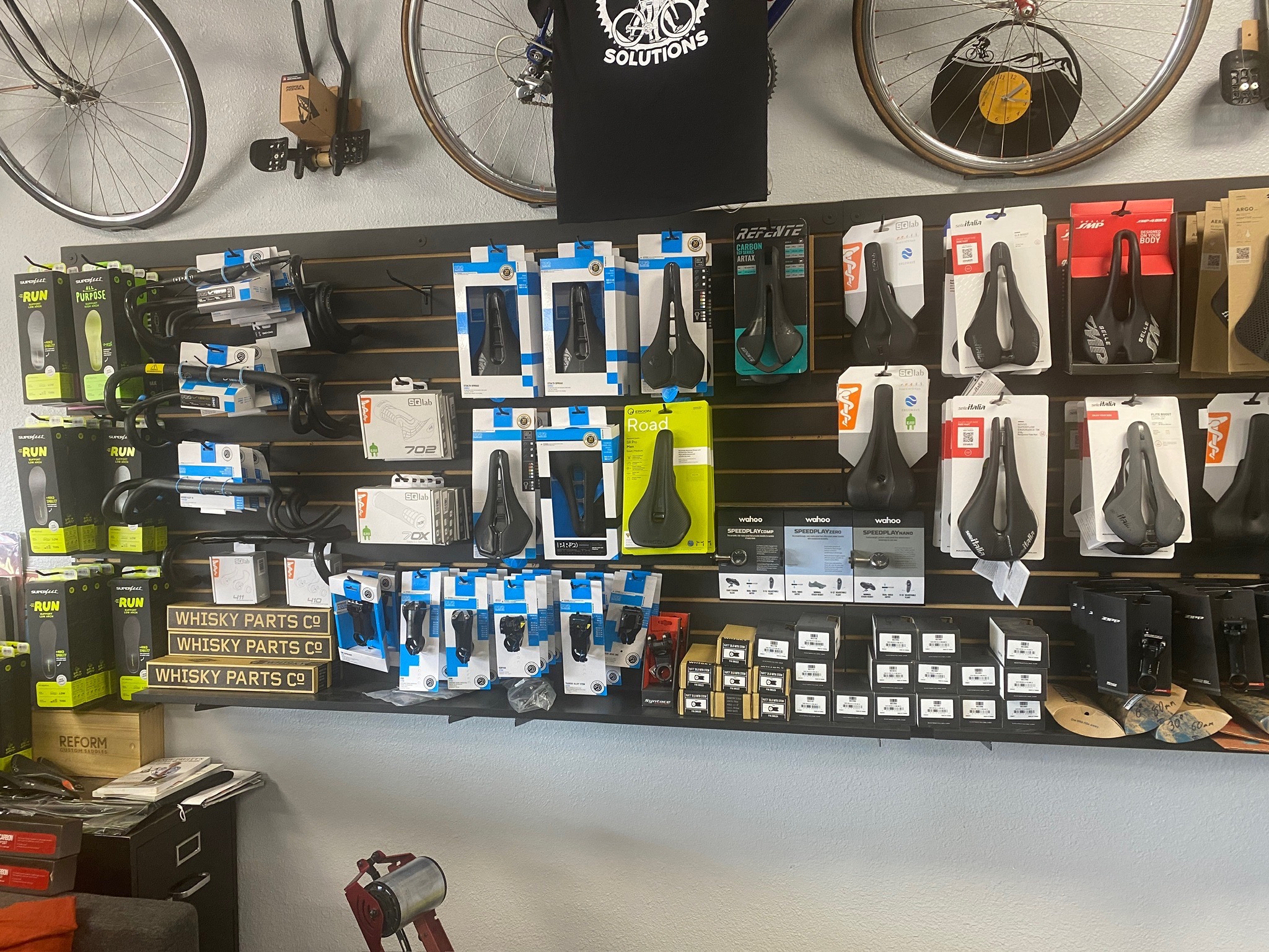 Saddles, pedals, and fitting components displayed at Guru Bikes