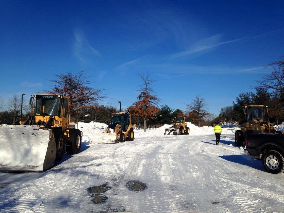 Snow plow and equipment clearing a commercial property in winter