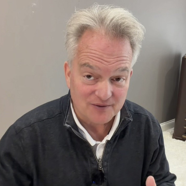 Tom talking to the camera at home beside a vintage console radio
