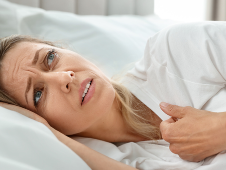 Woman having hot flashes in bed