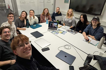 Großes Teammeeting: Zehn junge Mitarbeiter besprechen Projekte am Konferenztisch.