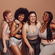 Mix race women in athletic wear posing against a solid brown background