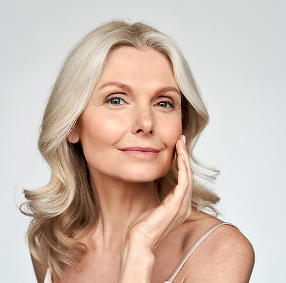 Middle age woman posing against a solid background close up of her face after HydraFacial