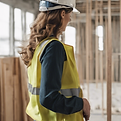 woman in a hardhat in a timber framed home managing a project site